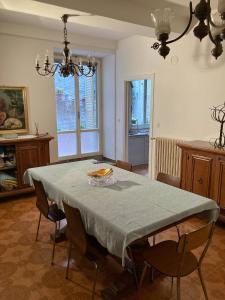 uma sala de jantar com uma mesa com cadeiras e um lustre em Il cortile di zia em Cagli