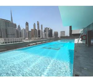 a swimming pool with a city skyline in the background at Burj Khalifa Poolside, Canal Boardwalk, Parking in Dubai