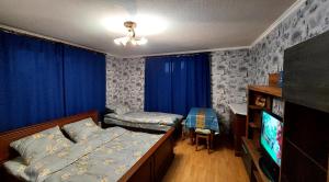 um quarto com uma cama e uma televisão de ecrã plano em Коттеджный городок Чапаевка, Голосеевкий район em Kiev