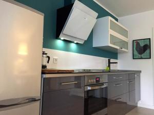 a kitchen with blue walls and a stove top oven at Ferienapartment am Möhnesee in Möhnesee +3 photos