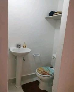 a white bathroom with a sink and a toilet at Comfortable Apartament in Los Paredones