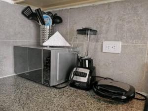 a blender sitting on a counter next to a microwave at Comfortable Apartament in Los Paredones