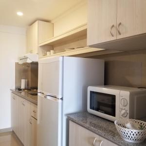 W kuchni znajduje się biała lodówka i kuchenka mikrofalowa. w obiekcie DELFINA suites 3A w mieście La Rioja