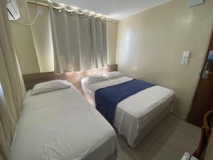 two beds in a small room withermottermottermott at Hotel Pousada dos Anjos in João Pessoa