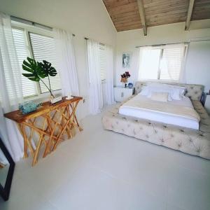 ein Schlafzimmer mit einem großen Bett und einem Tisch in der Unterkunft Tulixx Cayman Villa 