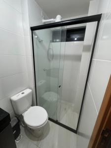 a bathroom with a toilet and a glass shower at Flat a 400 metros da praia!, ótima localização. in Cabedelo +13 photos
