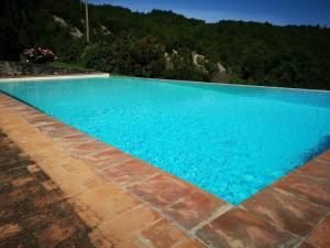 una gran piscina azul con una montaña en el fondo en Ferienhaus in Rotecastello mit Grill, Terrasse und Garten, en San Venanzo