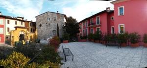 une cour avec un banc et quelques bâtiments dans l'établissement Stilvolle Wohnung in Toscolano Maderno mit Kleiner Terrasse, à Toscolano Maderno