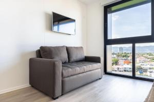 a couch in a living room with a large window at Brand new 1 bed loft with spectacular city view in El Empalme