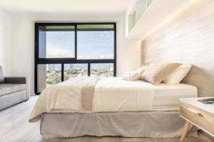 a bedroom with a bed and a large window at Brand new 1 bed loft with spectacular city view in El Empalme +16 photos