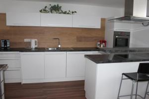 a kitchen with white cabinets and a sink at Ferienwohnung mit Blick auf die Berge in Bad Vigaun