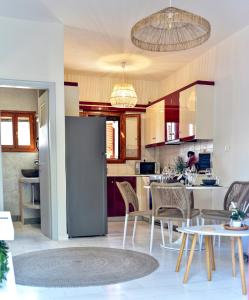 a kitchen with a refrigerator and a table and chairs at DP Homes Santorini in Perissa