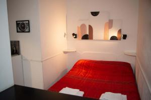 a small room with a red bed in it at Appartamento Cornelia in Rome