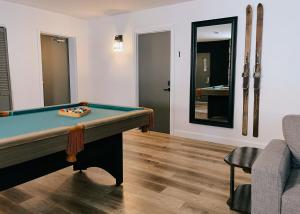 a pool table in a living room with a mirror at La Belle Excuse in Saint-Joachim