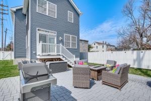 a patio with chairs and a grill in front of a house at Long Branch Beach House with Private Hot Tub! in Long Branch