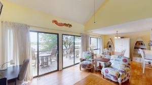 ein Wohnzimmer mit einem Tisch und Stühlen sowie einem Balkon in der Unterkunft Heron Marsh Escape Split Level Villa Lake Views in Pawleys Island