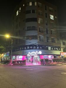 um edifício com uma placa à frente à noite em Apartamento en Laureles cerca a la 70 y Estadio - 702 em Medellín