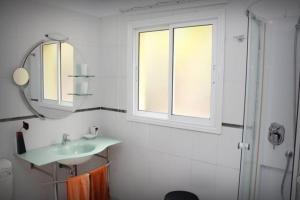 uma casa de banho com um lavatório, um espelho e uma janela em Ferienhaus mit einem Schlafzimmer, Kaminofen und Sonnenterrasse em Guía de Isora