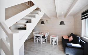 uma sala de estar com uma escada e uma mesa em Gemütliches Ferienhaus in Grzybowo mit Garten, Terrasse und Grill - b53705 em Grzybowo