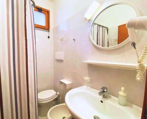 a bathroom with a sink and a toilet and a mirror at Hotel Lorenza B&B e Mini Suite in Cavoli