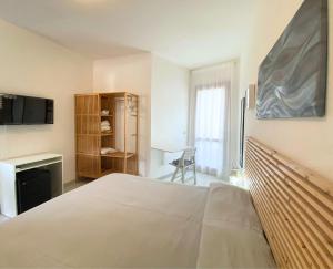 a bedroom with a bed and a desk and a tv at Hotel Lorenza B&B e Mini Suite in Cavoli