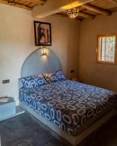 a bedroom with a bed with a blue comforter at Villa Dar Sarah (private pool and hammam, piscine privée et hammam) in Agadir