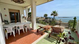 a patio with a table and chairs and the ocean at Cuore di Ognina - Appartamenti vista mare in Ognina