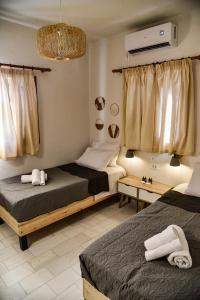 a bedroom with two beds and a tv on the wall at DP Homes Santorini in Perissa
