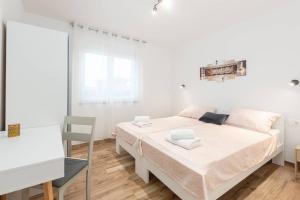 1 dormitorio blanco con 1 cama y 1 silla en Villa Ema und Ana, en Pula
