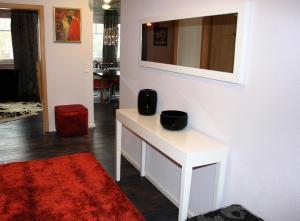 uma sala de estar com uma mesa branca e um tapete vermelho em Ferienwohnung für 3 Personen in Bad Saarow, Berlin em Bad Saarow