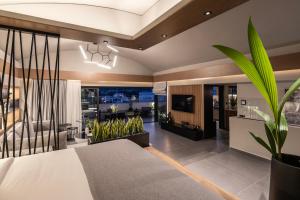 a living room with a bed and a television at The sand City apartment with Outdoor Hot Tub in Agios Nikolaos