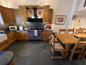 a kitchen with wooden cabinets and a wooden table at The Lodge Luxury Grade 2 listed house, Hot tub in Chesterfield
