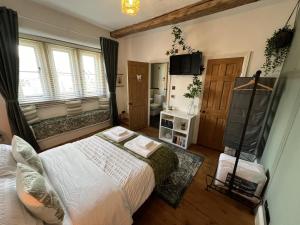 a bedroom with a large bed and a bathroom at The Lodge Luxury Grade 2 listed house, Hot tub in Chesterfield