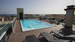a swimming pool on the roof of a building at Geams Sal Suite in Santa Maria