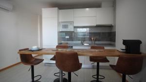 a kitchen with a wooden table and some chairs at Geams Sal Suite in Santa Maria