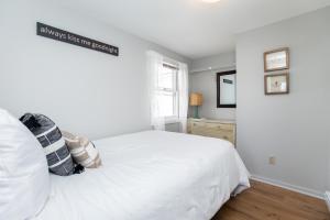 a bedroom with a white bed and a window at Hampton Beach Seaside Villa Unit 1 in Hampton