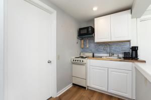 cocina blanca con fregadero y fogones en Hampton Beach Seaside Villa Unit 1, en Hampton