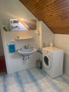 a bathroom with a washing machine and a sink at Revans teázó apartman- belváros in Pápa