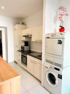 eine Küche mit einer Waschmaschine und einer Waschmaschine in der Unterkunft W Apartment - Brigittenau Area MM10 in Wien