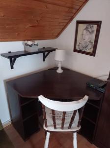 a room with a desk with a chair and a lamp at Revans teázó apartman- belváros in Pápa