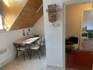 uma sala de jantar com uma mesa e cadeiras e uma escadaria em Revans teázó apartman- belváros em Pápa