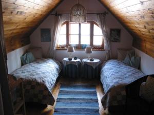 1 dormitorio con 2 camas y ventana en Komfortables Landhaus mit Gartengrundstück und Naturbadeteich direkt am Wald und verkehrsbegünstigt für Ausflüge, en Rettenberg