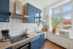 a kitchen with blue cabinets and a sink and a window at Ferienwohnung für 2 Personen ca 55 qm in Lübeck, Ostseeküste Deutschland Lübecker Bucht in Lübeck