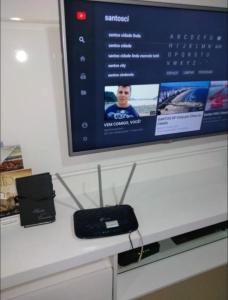 a tv on top of a counter with a remote control at Mar Doce Lar in Santos