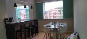 a dining room with a table and chairs and a window at Mar Doce Lar in Santos
