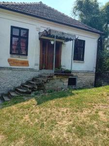 uma casa branca com uma porta da frente e um quintal em Country house pivnica Milic Rogljevo em Rogljevo