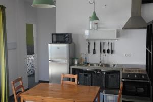 a kitchen with a table and a refrigerator and a sink at Finca "Ferienhaus" mit Schwimmbad in Bérchules