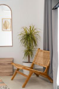 uma cadeira de vime num quarto com um vaso de plantas em SarandaView Hotel em Saranda
