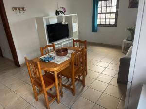 a dining room table with chairs and a television at Apartamento Tabaiba in Tamaduste