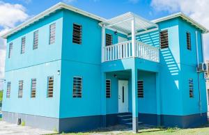 a blue house with a white at Ruby's Place in Cassada Gardens